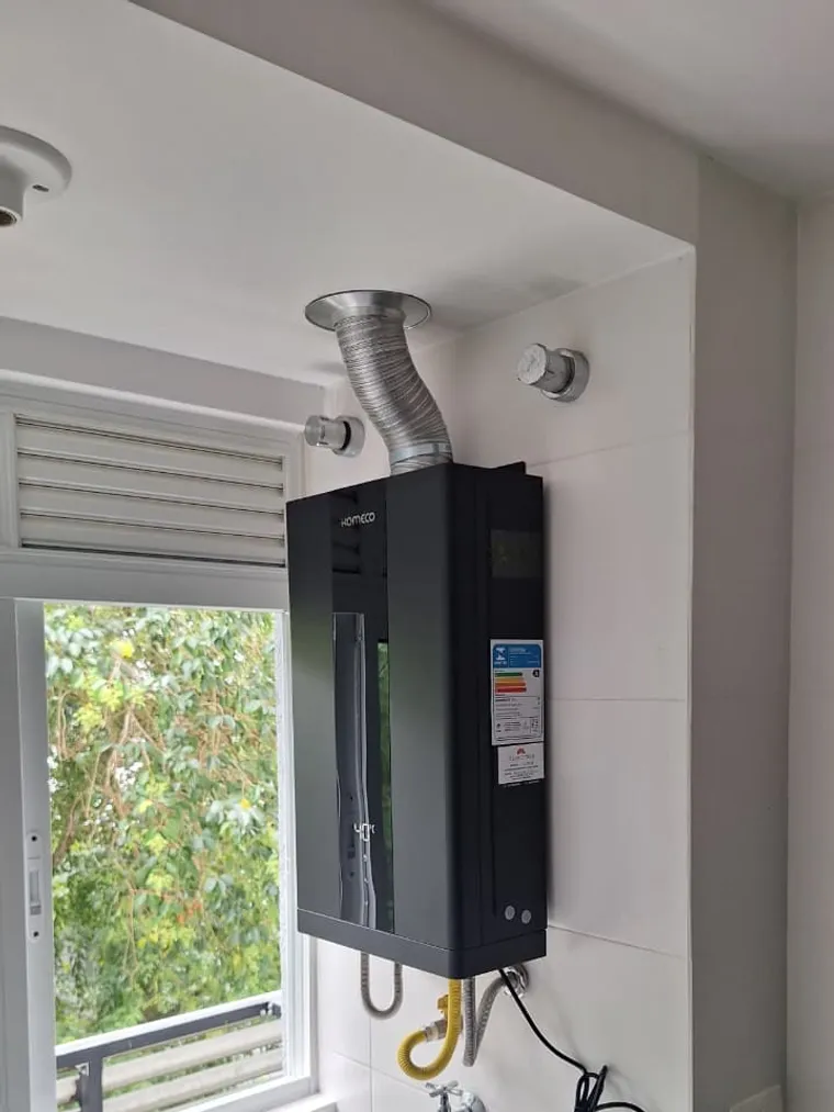 Instalação de aquecedor a gás Komeco preto em área de serviço em Curitiba, feita pela Astral Gás